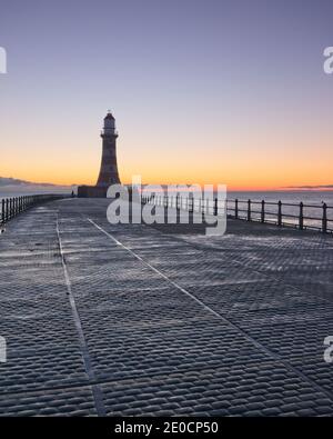 Sonnenaufgang am Roker Pier und Leuchtturm, der von der Nordseeküste bei Sunderland, Tyne und Wear, Nordostengland, reicht. Stockfoto