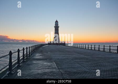 Sonnenaufgang am Roker Pier und Leuchtturm, der von der Nordseeküste bei Sunderland, Tyne und Wear, Nordostengland, reicht. Stockfoto