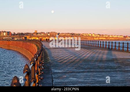 Leute, die einen frühen Morgenspaziergang an einem kalten Dezembertag auf Roker Pier, Sunderland, Tyne Wear machen. Stockfoto