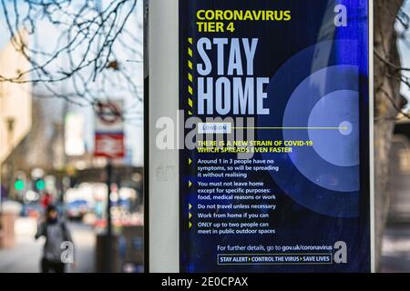 Ein Mann geht an einem Schild mit dem Coronavirus „Stay Home“ in Vauxhall vorbei. London wurde unter Tier 4-Beschränkungen gestellt, da die Fälle ansteigen und neue COVID-Stämme Stockfoto