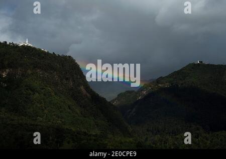 Regenbogen zwischen Monserrate und Guadalupe Hügel in der kolumbianischen Hauptstadt Bogota Mit Wolke Wald Berge Bäume Cundinamarca Stockfoto