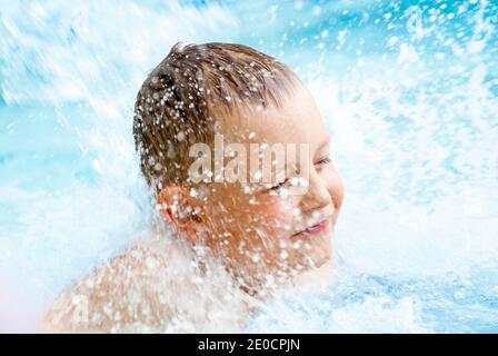 Ein Kind Junge spielt mit Wasser in Park Brunnen. Heißer Sommer. Stockfoto