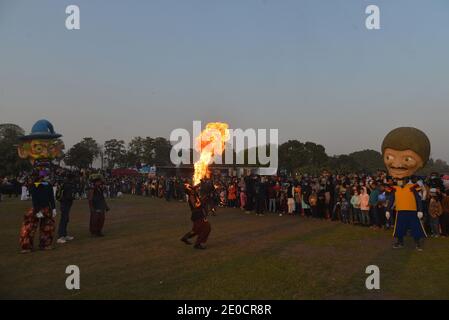 Lahore, Pakistan. Dezember 2020. Pakistani eine große Anzahl von Familien sitzen in den Boden nehmen an "Family Winters Festival" auf der Rennstrecke Jilani Park in der Provinzhauptstadt Lahore. Familien genießen das Dinosauriermodell und die Show „Breathing Fire from Mouth“ während des „Family Winters Festival“ auf dem Pferderennplatz Jilani Park. (Foto von Rana Sajid Hussain/Pacific Press) Quelle: Pacific Press Media Production Corp./Alamy Live News Stockfoto