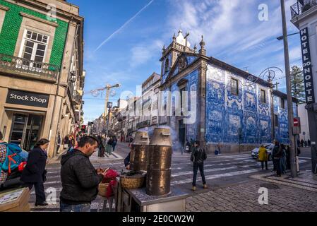 Mann, Verkauf von gerösteten Kastanien neben Capela Das Almas (auch genannt Capela Das Santa Catarina) - Kapelle der Seelen in der Stadt Porto, Portugal Stockfoto
