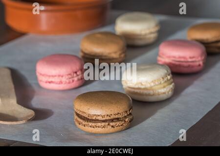 Eine Nahaufnahme von frisch gebackenen hausgemachten Makronen oder Macarons in Schokolade, Vanille und Rosa Stockfoto