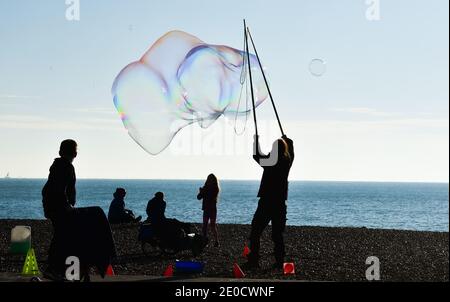 Brighton UK 31. Dezember 2020 - Blasen in der Luft an der Strandpromenade von Brighton während Spaziergänger das sonnige, aber kalte Wetter an Silvester entlang der Südküste genießen. Kredit Simon Dack / Alamy Live Nachrichten Stockfoto