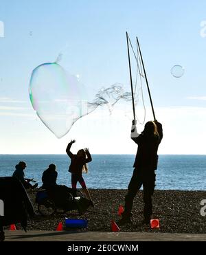 Brighton UK 31. Dezember 2020 - Blasen in der Luft an der Strandpromenade von Brighton während Spaziergänger das sonnige, aber kalte Wetter an Silvester entlang der Südküste genießen. Kredit Simon Dack / Alamy Live Nachrichten Stockfoto