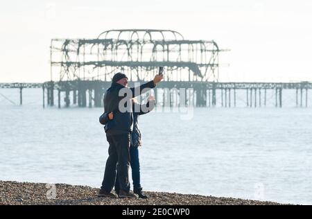 Brighton UK 31. Dezember 2020 - Zeit für ein Selfie am Brighton West Pier, während Wanderer das sonnige, aber kalte Wetter entlang der Küste an Silvester genießen. Kredit Simon Dack / Alamy Live Nachrichten Stockfoto