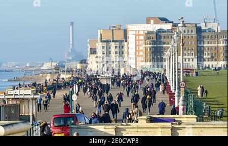 Brighton UK 31. Dezember 2020 - Wanderer genießen das sonnige, aber kalte Wetter entlang der Küste von Hove an Silvester. Kredit Simon Dack / Alamy Live Nachrichten Stockfoto