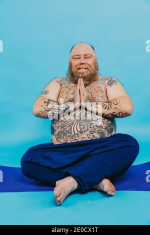 Lustige fette Mann tun Yoga-Meditation, lustig und ironisch Charakter Stockfoto