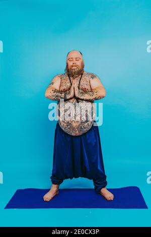Lustige fette Mann tun Yoga-Meditation, lustig und ironisch Charakter Stockfoto