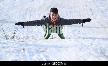 Jake Edwards genießt es, im Tatton Park, Knutsford, Cheshire, im Schnee zu rodeln, nachdem die Temperaturen über Nacht unter den Gefrierpunkt gefallen sind. Stockfoto