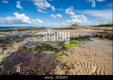 Northumberland. Dies ist die Festung von Bambrugh Castle mit Blick über den Sand der Embleton Bay in Northumberland. Die Burg war die wichtigste Hochburg gegen Überfälle durch die Wikinger im 11. Jahrhundert und ist nach dem Dorf Bambrugh benannt Stockfoto