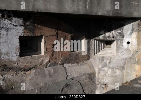 Detail von Militärbunker und Pillbox aus dem 2. Weltkrieg - steppen-Schießschnur und Loch für Kanone in der grauen Wand aus Beton. Stockfoto