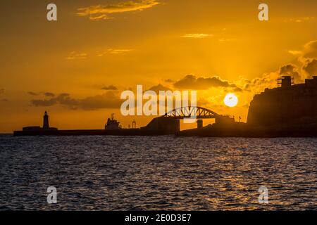 Sonnenaufgang über der St Elmo Brücke und dem Grand Harbour in Valletta, Malta. Stockfoto