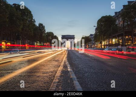 An einem Sommerabend in Paris, Fran, lassen sich leichte Wege vom Autoverkehr entlang der Champs-Elysess zum berühmten Wahrzeichen Arc dr Triomphe zurückbringen Stockfoto