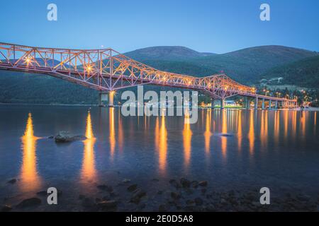 Die ikonische Big Orange Bridge in Nelson, B.C. an einem Sommerabend nach Sonnenuntergang. Stockfoto