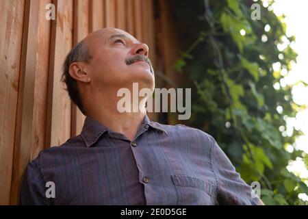 Nachdenklicher älterer hispanischer Mann, der im Freien aufschaut Stockfoto