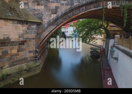 Ein Blick unter einem der Bögen der Karlsbrücke (Karlovy Most) mit der Moldau in Prag, Tschechische Reoublic. Stockfoto
