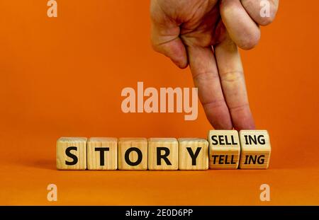 Storytelling oder Storyselling Symbol. Männliche Hand dreht Holzwürfel und ändert das Wort "storytelling" zu "storyselling". Schöner orangefarbener Hintergrund, Stockfoto