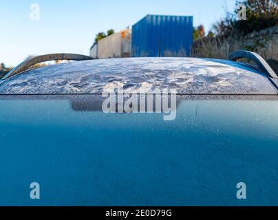 Autoscheibe mit Eis und wirbeligen Eismustern auf dem Autodach in Winter Sunshine, Schottland, Großbritannien Stockfoto