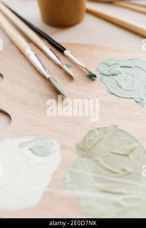 Von oben der Farbpalette mit Pastellpigmenten aufgesetzt Tisch mit Bürsten im Kunststudio Stockfoto