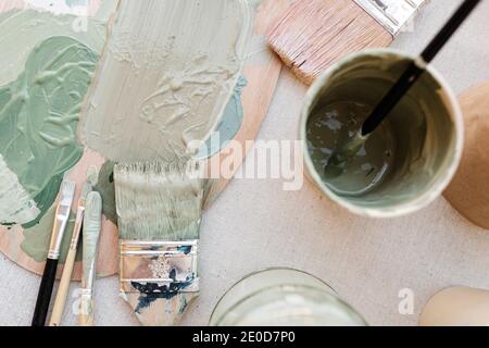 Von oben der Farbpalette mit Pastellpigmenten aufgesetzt Tisch mit Bürsten im Kunststudio Stockfoto