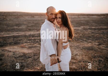 Bärtig fröhlicher Vater unterrichtet Sohn mit Hammer arbeiten mit Holz, während auf der Promenade am Wochenende sitzen Stockfoto