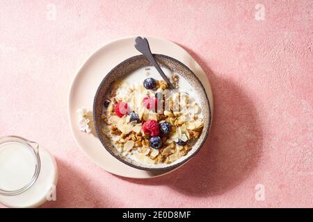 Blick von oben auf leckeres Frühstück mit Müsli, Beeren und Milch Stockfoto