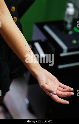 Von oben der Ernte unkenntlich weiblich mit zarten Tattoo auf Arm in Schönheitssalon Stockfoto