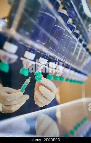 Nicht erkennbarer Kosmetologe in Handschuhen Füllen Spritze mit chemischer Flüssigkeit für Hautpflege Verfahren in der modernen Beauty-Klinik Stockfoto