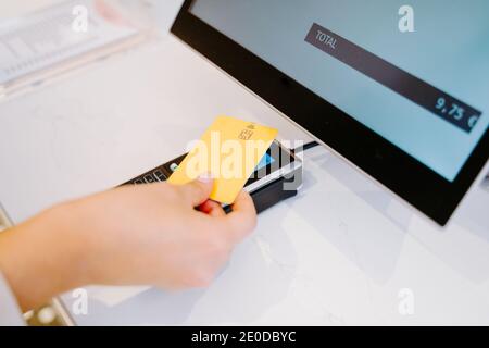 Hoher Winkel der Ernte unkenntlich weibliche Käufer mit Plastikkarte Und die Bezahlung für Bestellung am POS-Terminal Stockfoto