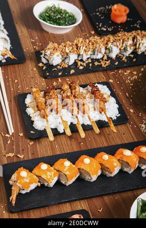 Draufsicht auf Sushi und Brötchen auf Holz Tisch im Restaurant mit asiatischem Essen Stockfoto