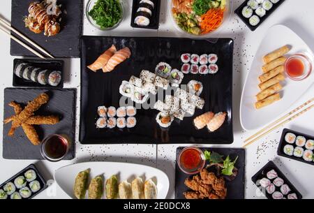 Von oben aus verschiedene Sushi und Brötchen auf den Tisch gelegt Im asiatischen Restaurant Stockfoto