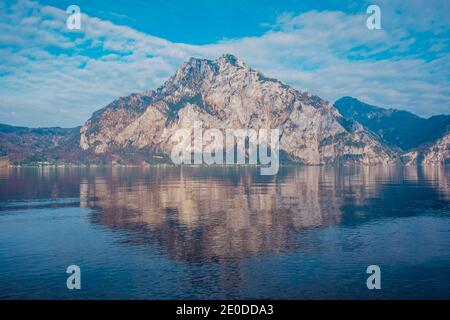 Malerische Landschaft von massiven felsigen Berg spiegelt sich im Wasser see gegen wolkigen blauen Himmel in Hallstatt Stockfoto