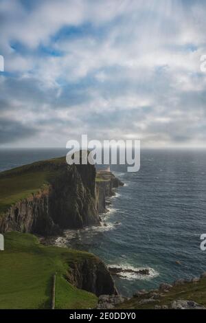 Erstaunliche abgelegene Luftaufnahme des Neist Point Lighthouse befindet sich auf Grüne Felsklippe vor dem ruhigen Meer auf sonnigen Tag in Schottland Stockfoto