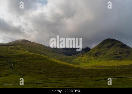 Atemberaubende Landschaft mit felsigen Bergen gegen grau bewölkten Himmel in Schottland Stockfoto