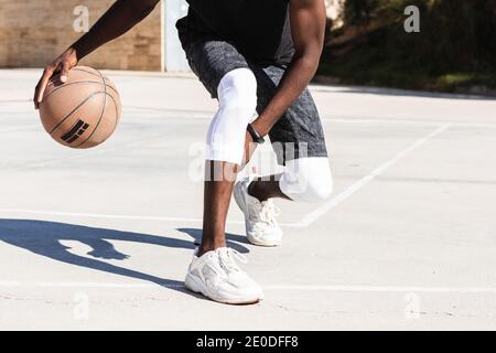 Cropped unkenntlich afroamerikanischen männlichen Athleten spielen Basketball auf dem Platz Im Sommer und Blick auf die Kamera Stockfoto