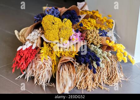 Bunte verschiedene frische und getrocknete Blumen in Blumensträußen verpackt angeordnet In Bastelpapier im Blumenladen Stockfoto