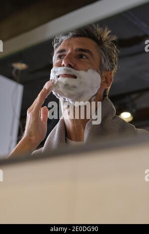 Stock Foto von Mann mittleren Alters mit grauen Haaren Vorbereitung für die Rasur seinen Bart im Badezimmer. Stockfoto