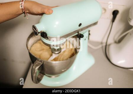 Hoher Winkel der Ernte anonyme weibliche Konditorei mit elektrischen Mixer Während der Zubereitung von Teig für Gebäck in der Küche Stockfoto