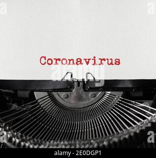 Mechanische Schreibmaschine in der Mitte mit einem weißen Blatt Papier. Metallische Maschine mit geschriebendem Text Coronavirus. Pandemiekonzept. Coronavirus Stockfoto