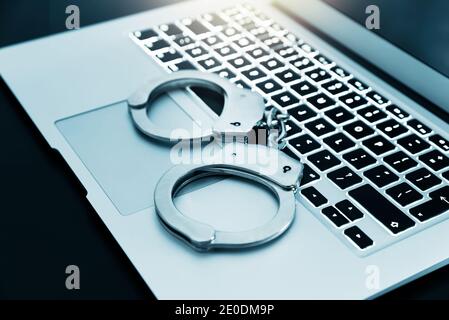 Internet Crime Konzept. Handschellen auf der Laptop-Tastatur, Cyber-Kriminalität Konzept Stockfoto