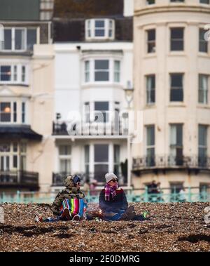 Brighton UK 31. Dezember 2020 - am Brighton Beach versammeln sich die Menschen, wenn die Sonne am 2020 an der Südküste von Großbritannien untergeht. Kredit Simon Dack / Alamy Live Nachrichten Stockfoto