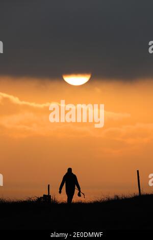 Cuckmere Haven, Seaford, Großbritannien. Dezember 2020. Die Sonne geht zum letzten Mal 2020 unter, während Wanderer die Aussicht von den Seven Sisters Cliffs in Sussex genießen.Quelle: James Boardman/Alamy Live News Stockfoto