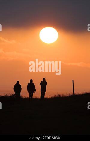 Cuckmere Haven, Seaford, Großbritannien. Dezember 2020. Die Sonne geht zum letzten Mal 2020 unter, während Wanderer die Aussicht von den Seven Sisters Cliffs in Sussex genießen.Quelle: James Boardman/Alamy Live News Stockfoto