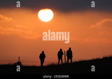 Cuckmere Haven, Seaford, Großbritannien. Dezember 2020. Die Sonne geht zum letzten Mal 2020 unter, während Wanderer die Aussicht von den Seven Sisters Cliffs in Sussex genießen.Quelle: James Boardman/Alamy Live News Stockfoto