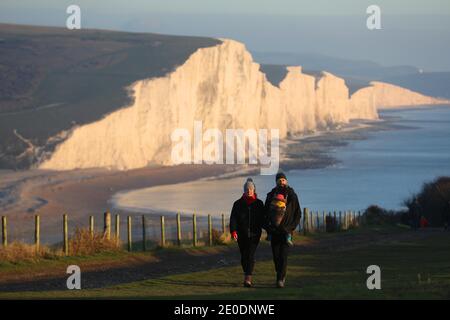 Cuckmere Haven, Seaford, Großbritannien. Dezember 2020. Die Sonne geht zum letzten Mal 2020 unter, während Wanderer die Aussicht von den Seven Sisters Cliffs in Sussex genießen.Quelle: James Boardman/Alamy Live News Stockfoto