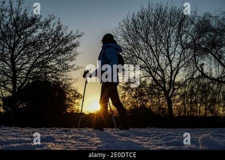 Kidderminster, Großbritannien. Dezember 2020. UK Wetter: Mit Schnee auf dem Boden und eisigen Temperaturen, ist es ein eisiger Abschluss zu Silvester. Die Leute in Worcestershire sind unterwegs, um die letzten Sonnenstrahlen des Winters einzufangen und zu stoppen, um den goldenen Glanz des Abenduntergangs zu genießen, wie wir Auf Wiedersehen bis 2020 sagen. Kredit: Lee Hudson/Alamy Live Nachrichten Stockfoto