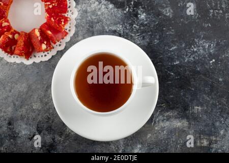 Eine weiße Tasse heißen Tee mit geschnittenem Dessert Stockfoto